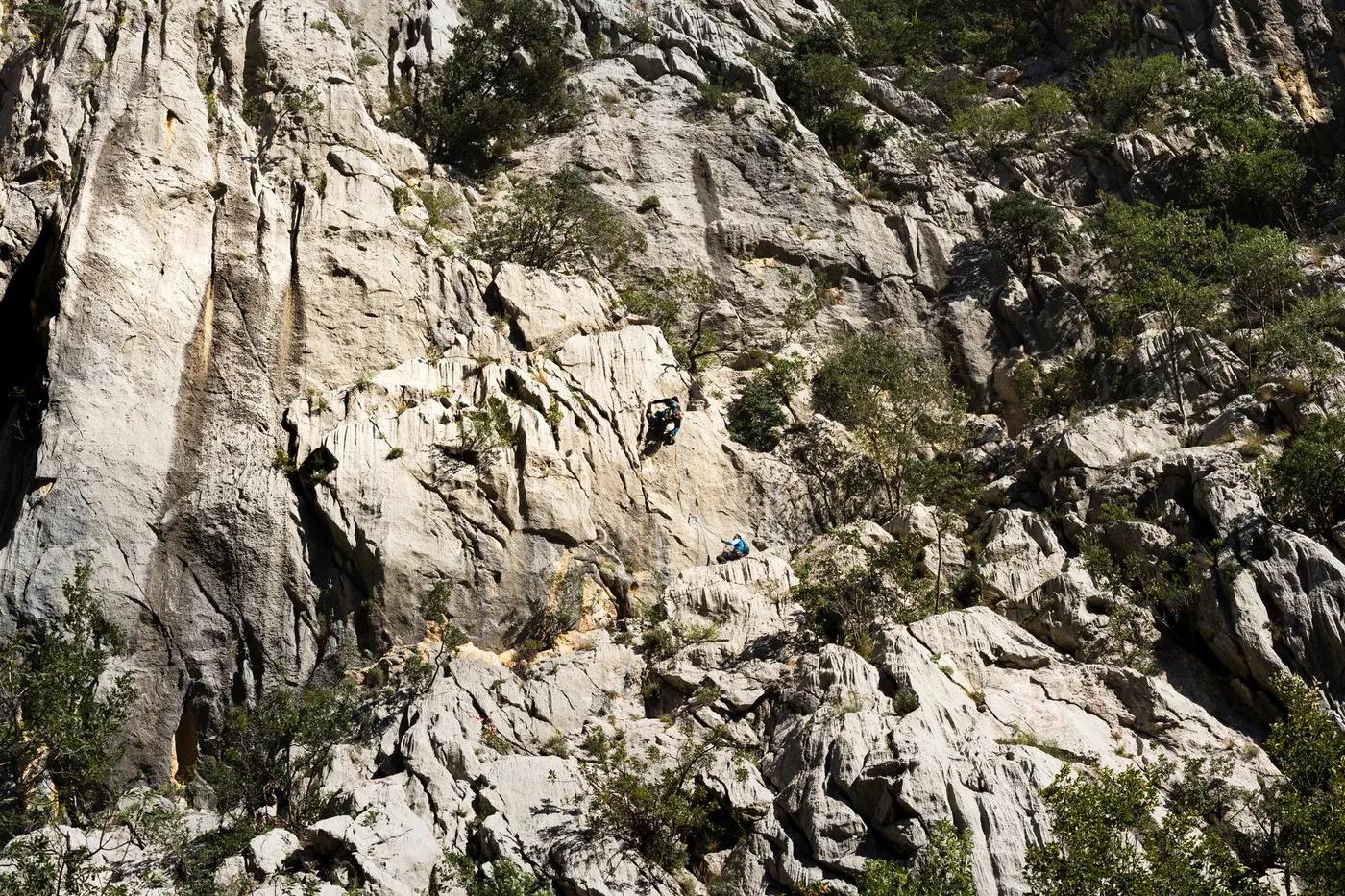 Two climbers ascend a rugged mountain face, showcasing adventure and skill.