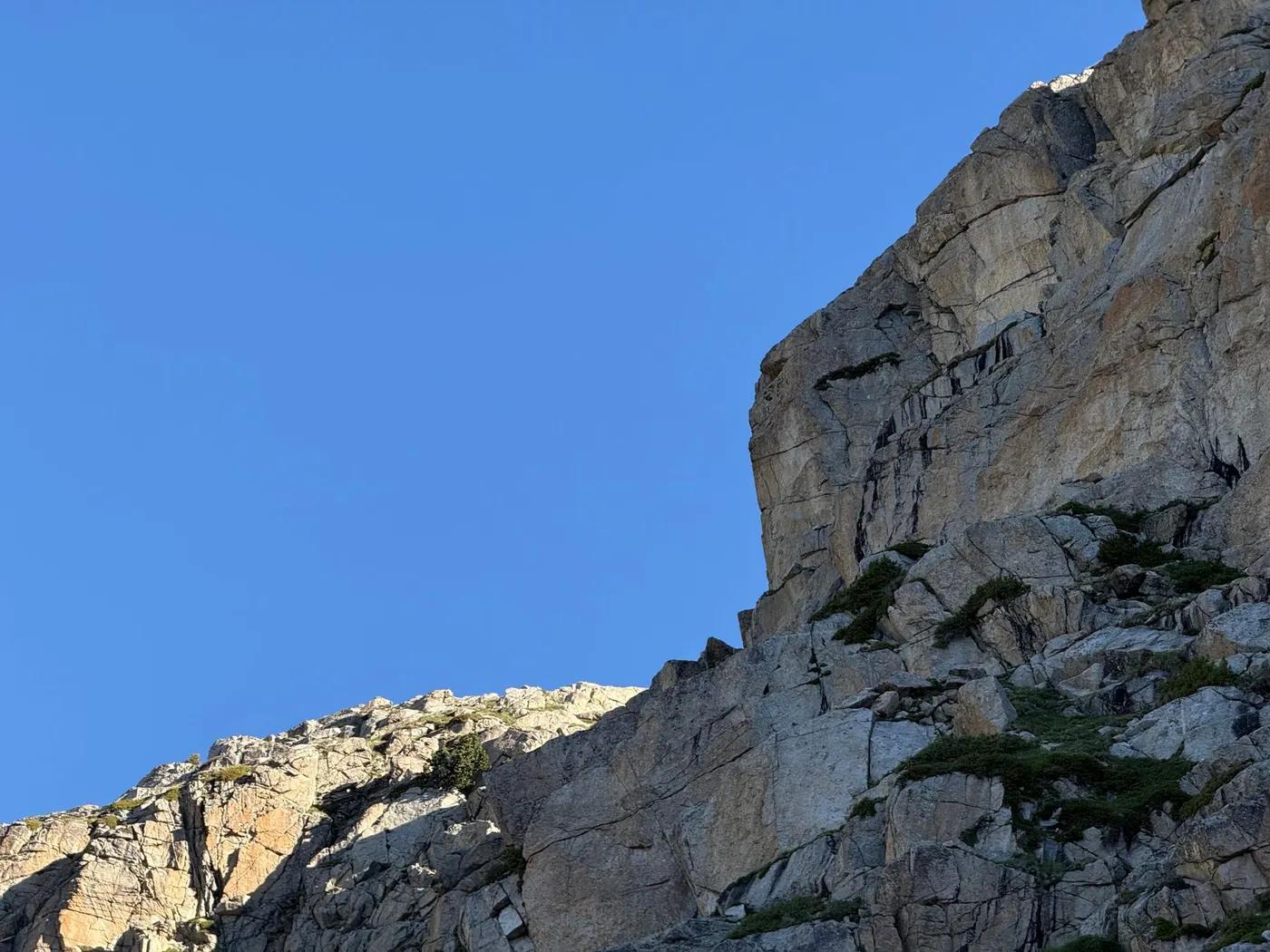 A stunning view of a rocky mountain peak under a vibrant blue sky in the Pyrenees, near Barcelona, Spain.