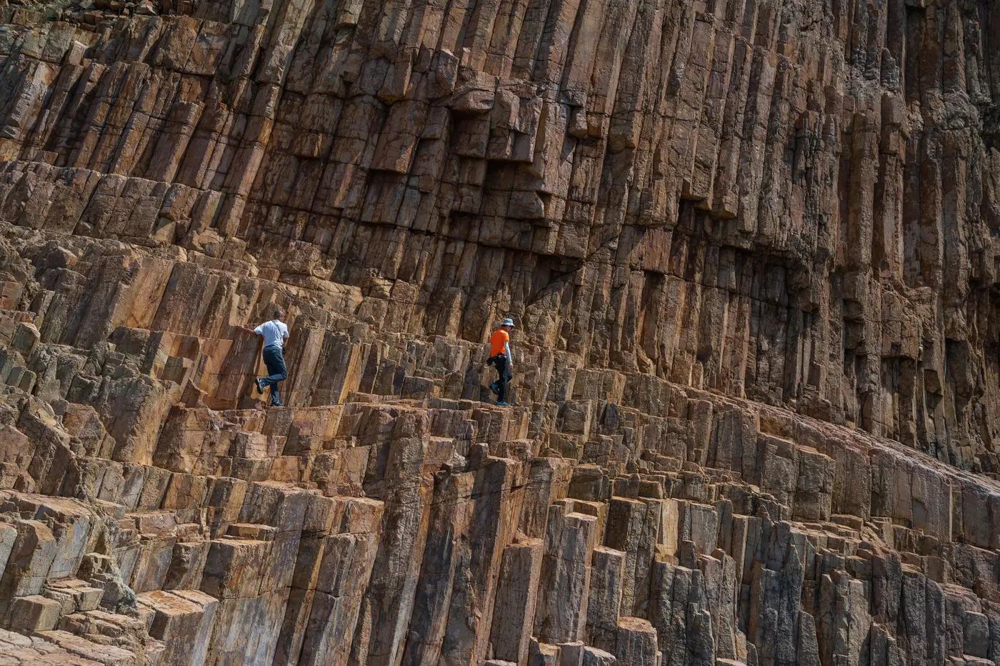 Adventurers scaling unique volcanic rock formations outdoors.