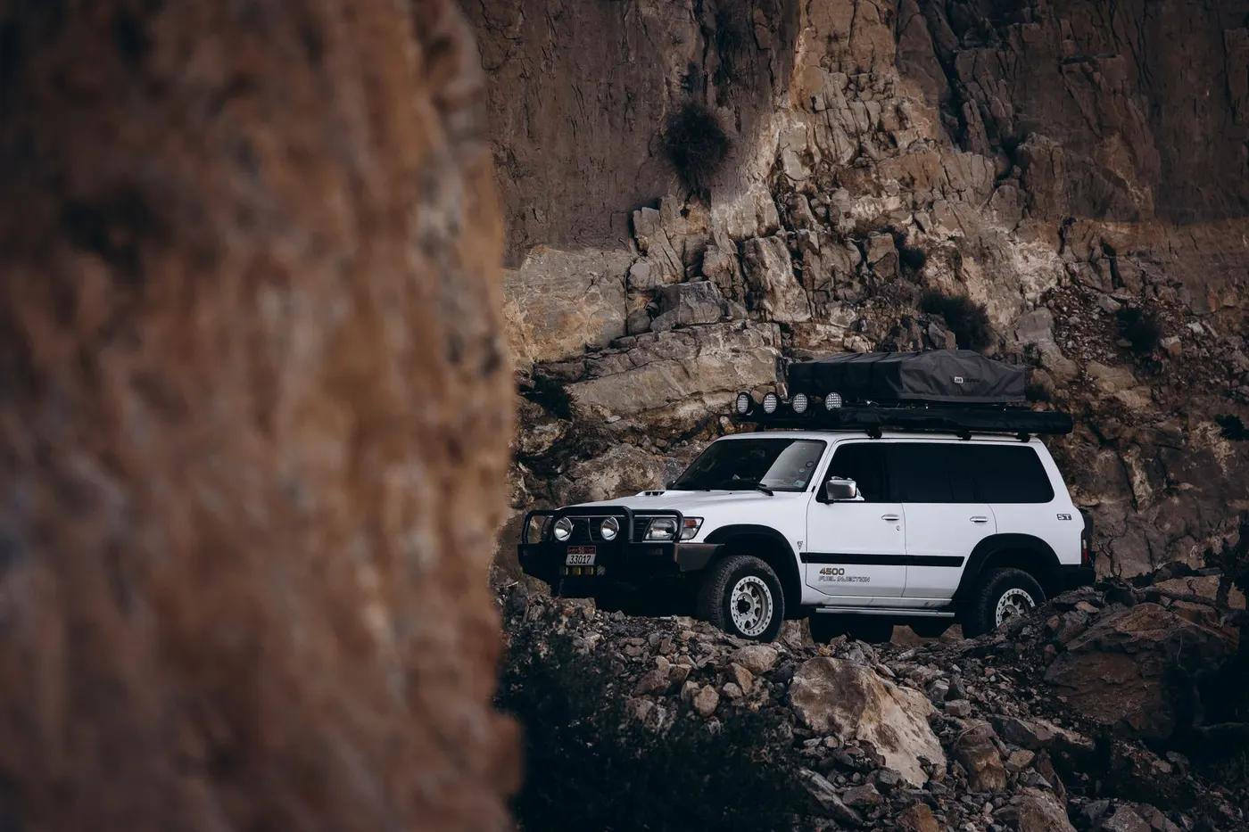 A robust SUV navigating the rocky landscapes of Oman, embodying adventure and exploration.