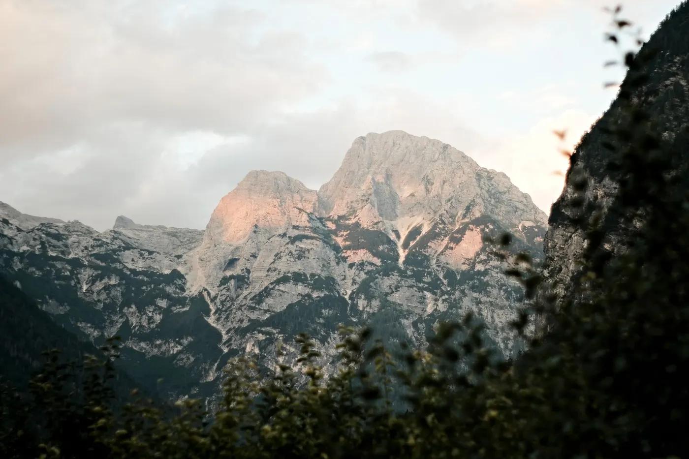 Stunning view of Soča mountains in Slovenia with sunset glow, capturing nature's tranquility.