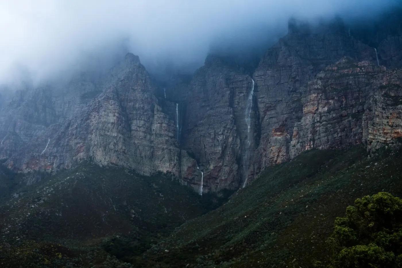 Misty landscape of majestic waterfalls cascading down rocky mountains in South Africa