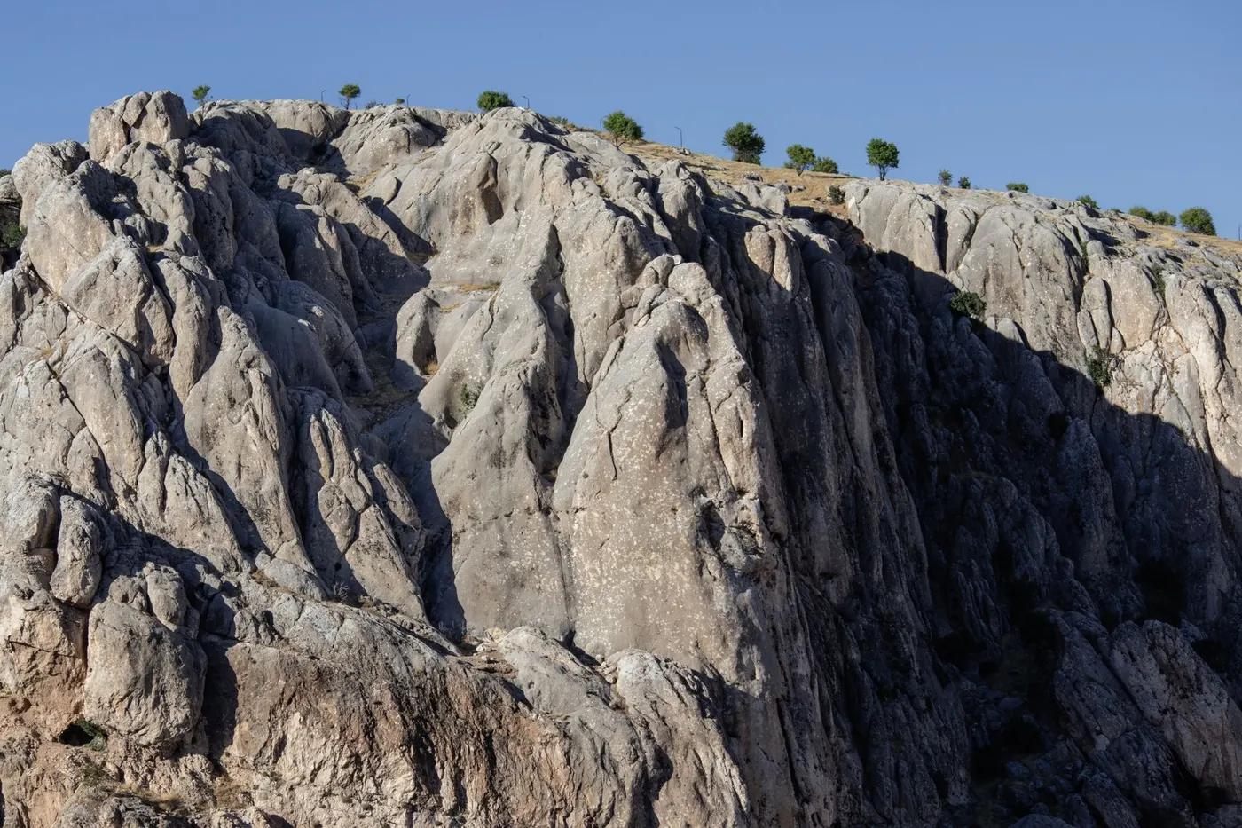 Majestic rocky cliff under clear blue sky in Elazığ, Türkiye, showcasing natural beauty.