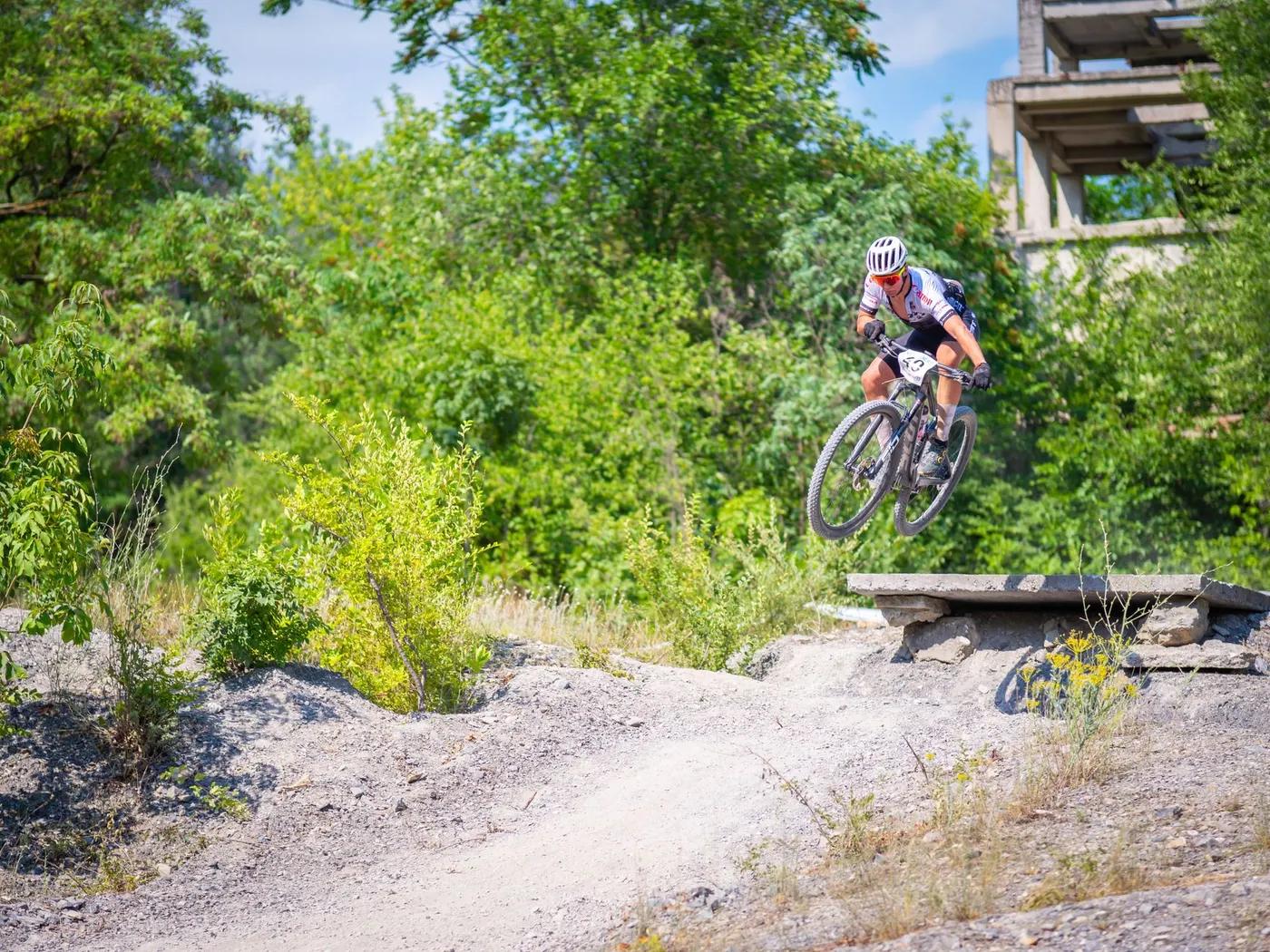 Mountain biker jumps over rocky terrain performing a stunt in Tulcea, Romania.