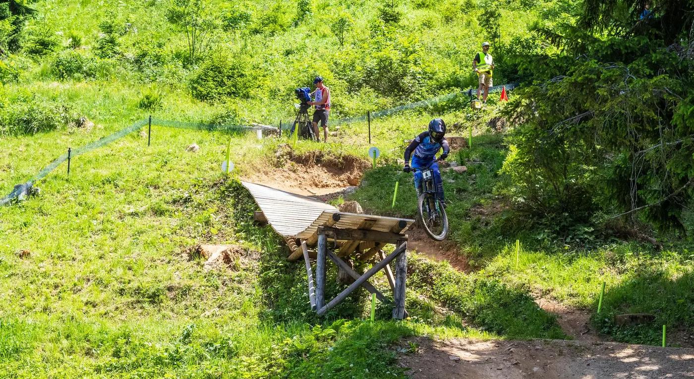 Biker performing jump at mountain biking competition in Graubünden, Switzerland.