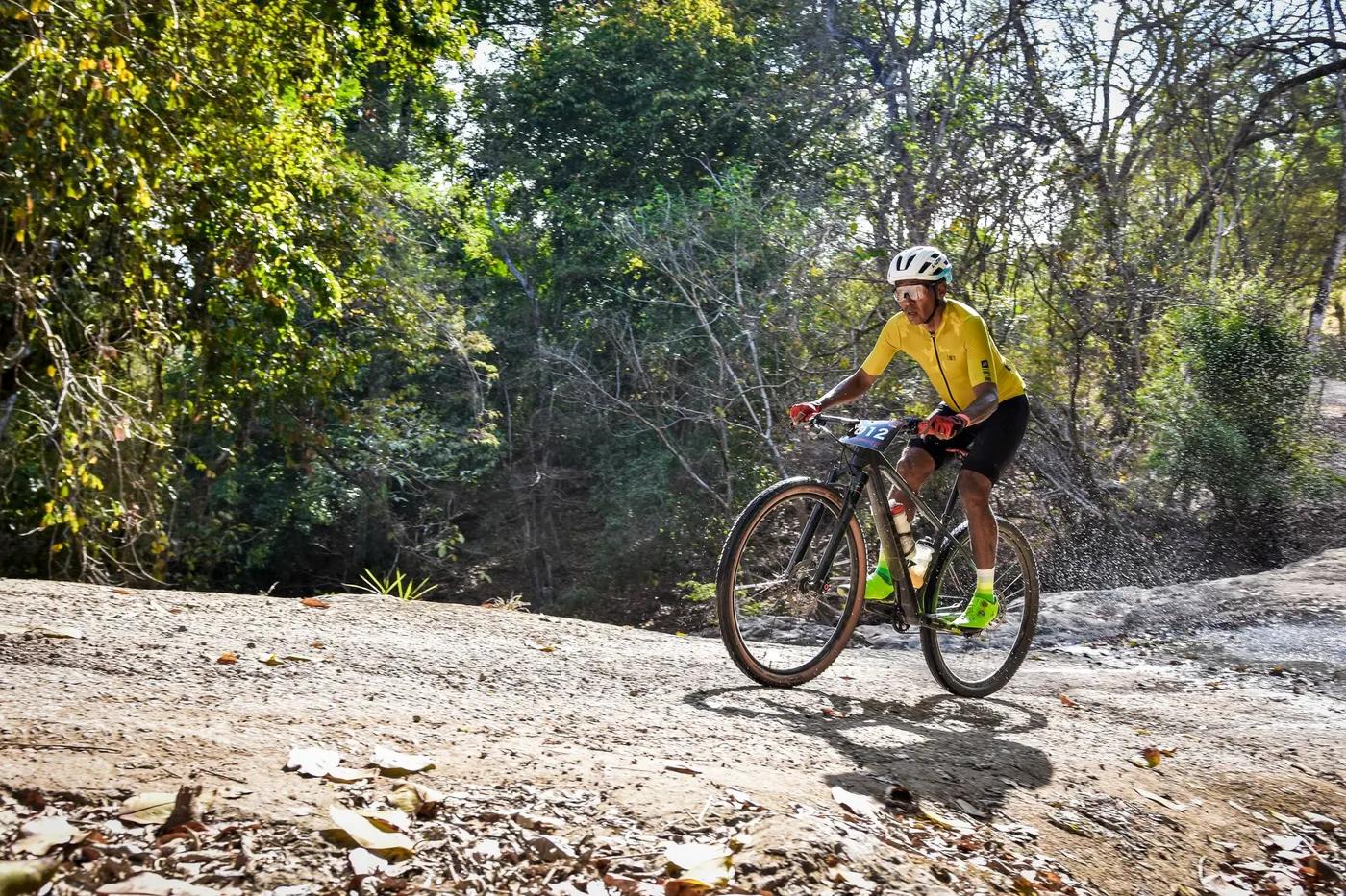 Mountain biker in sportswear riding through a forest trail in a thrilling race.