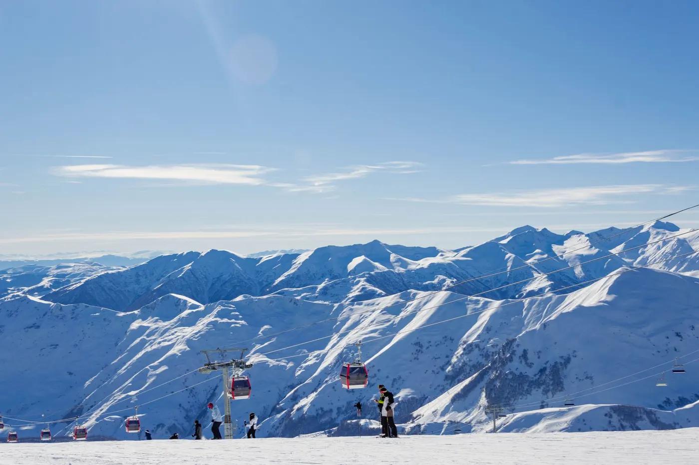 Capture the beauty of Gudauri's snowy peaks and ski lifts against a clear blue sky.