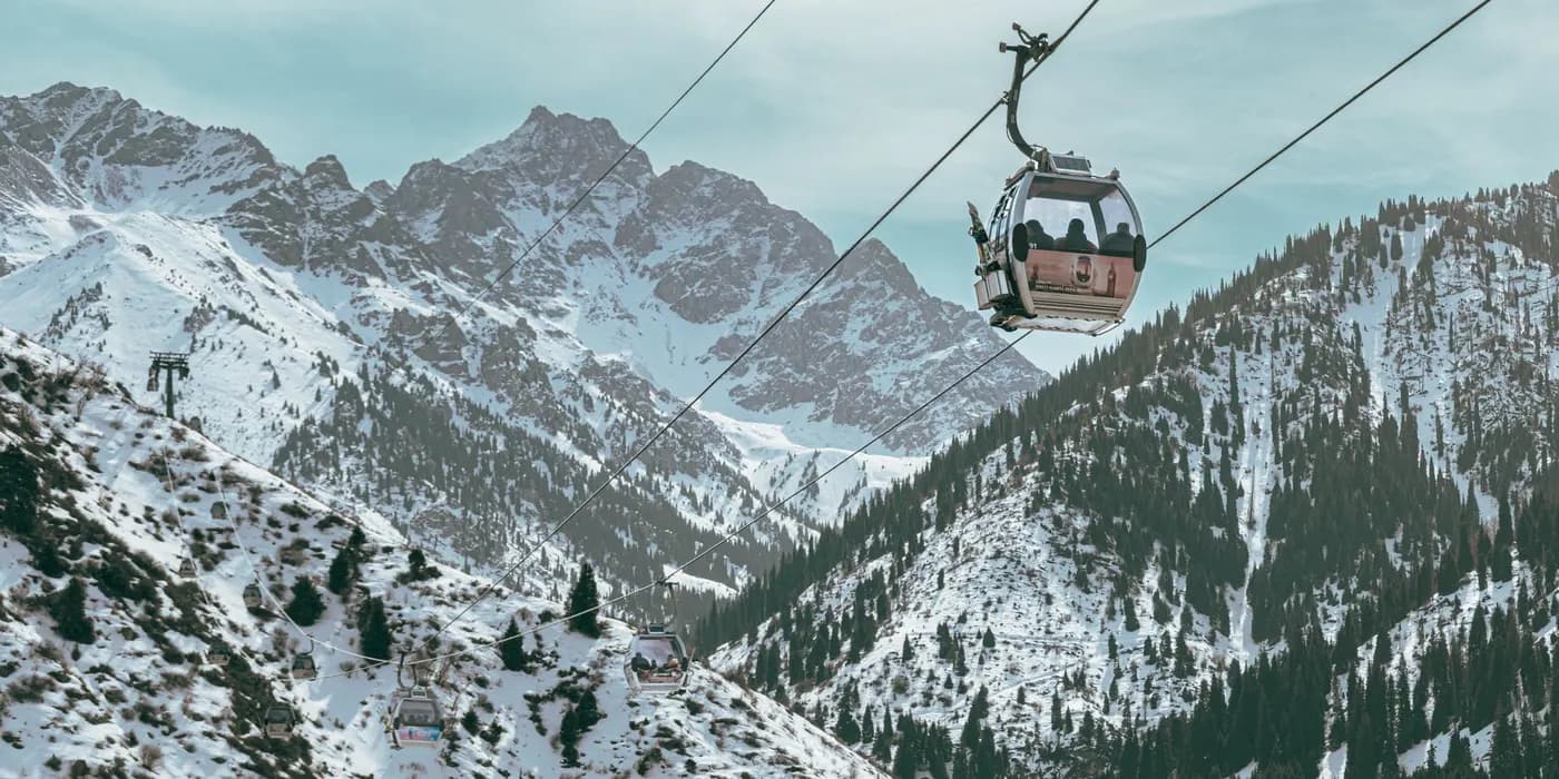Scenic view of a cable car over snow-covered mountains in Almaty, Kazakhstan during winter.