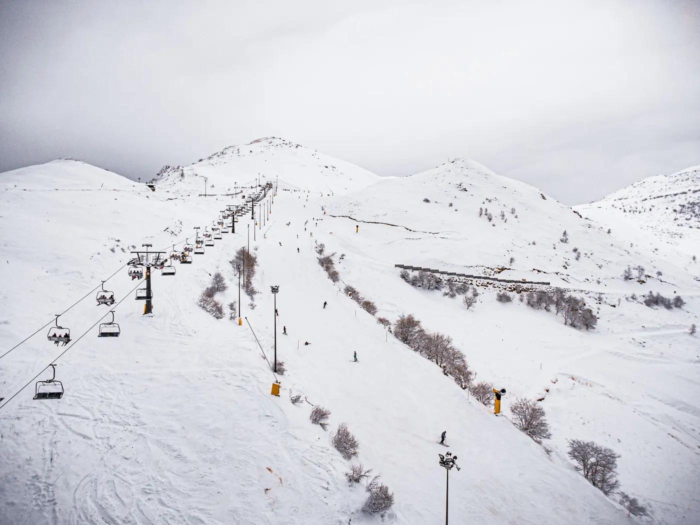 Captivating snowy ski slope with a ski lift and skiers, showcasing a winter adventure scene.
