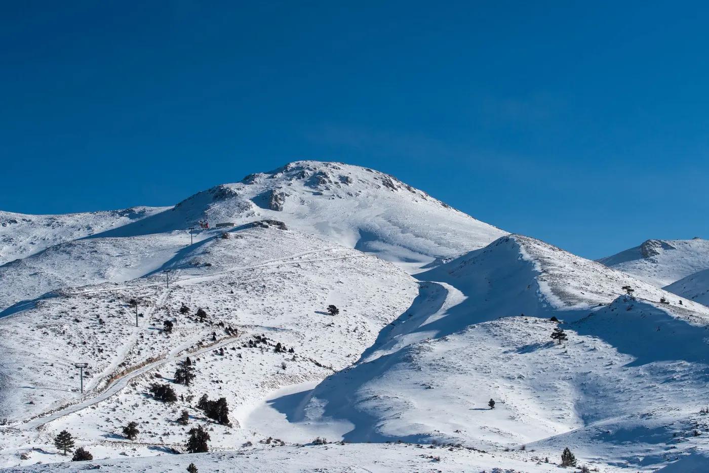 Captivating snowy mountain landscape under clear blue sky in Denizli, Türkiye.