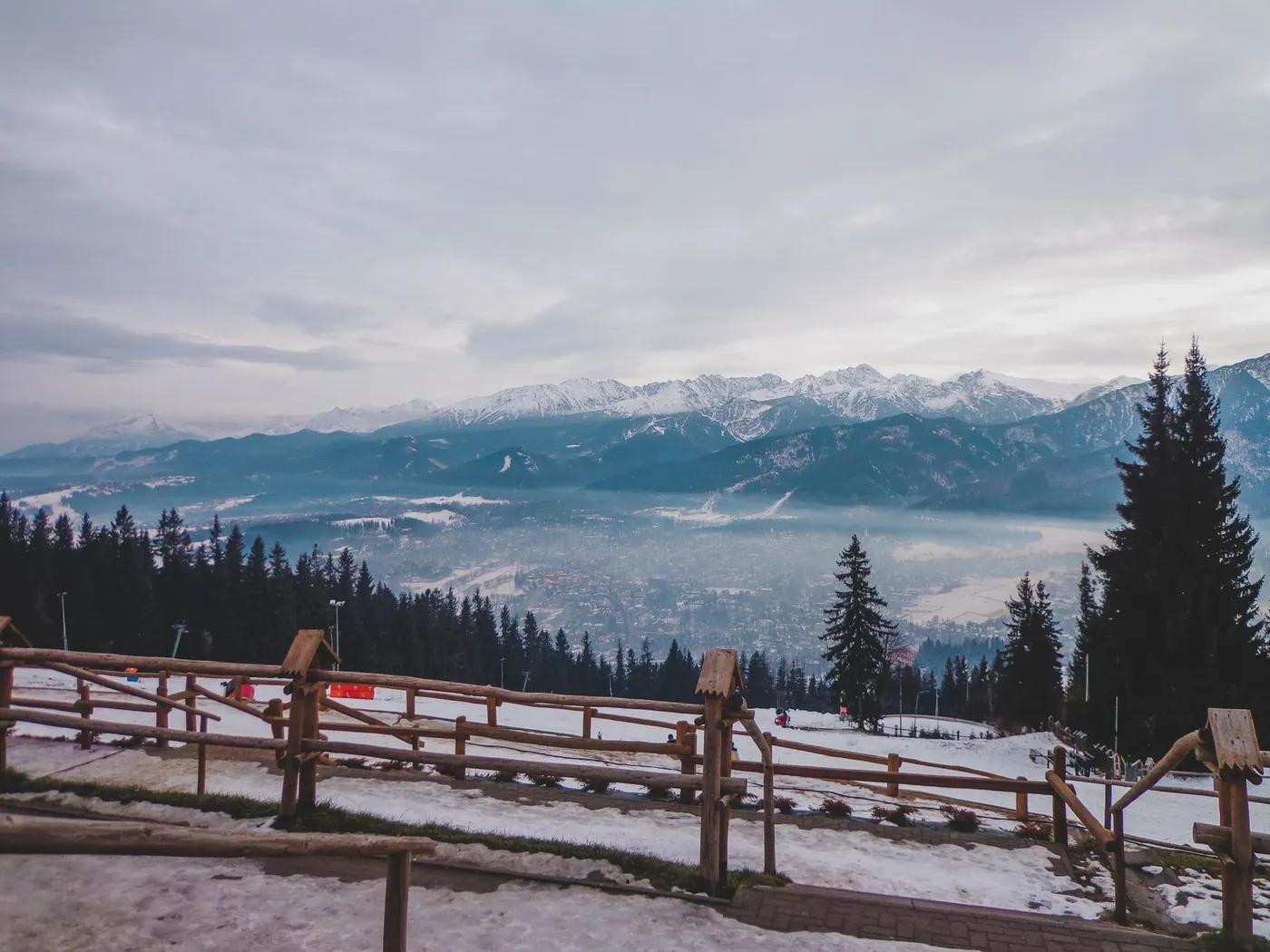 Breathtaking view of the snow-covered Tatra Mountains with fog over the valley in Poland.