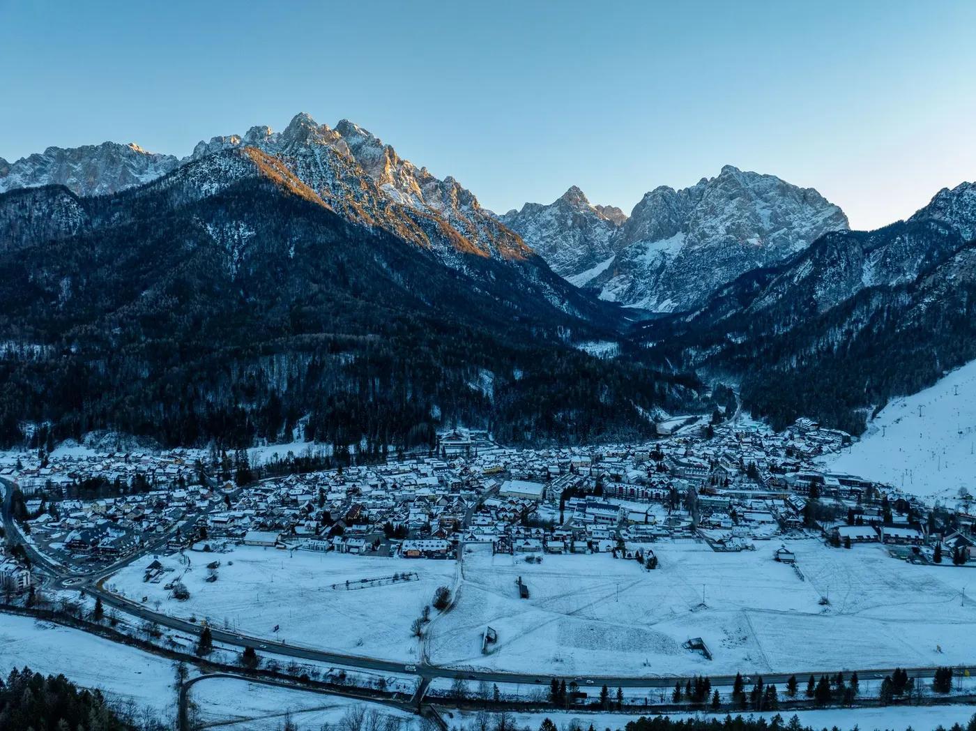 A stunning aerial view of Kranjska Gora, Slovenia, blanketed in snow with mountain backdrop.