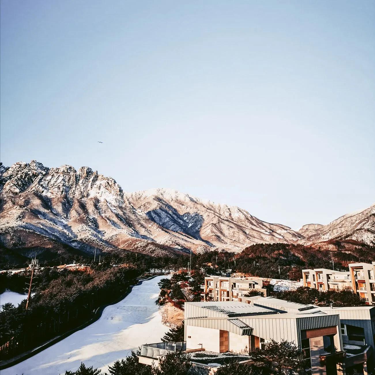 Scenic view of snow-covered Seoraksan Mountain and modern architecture in South Korea.