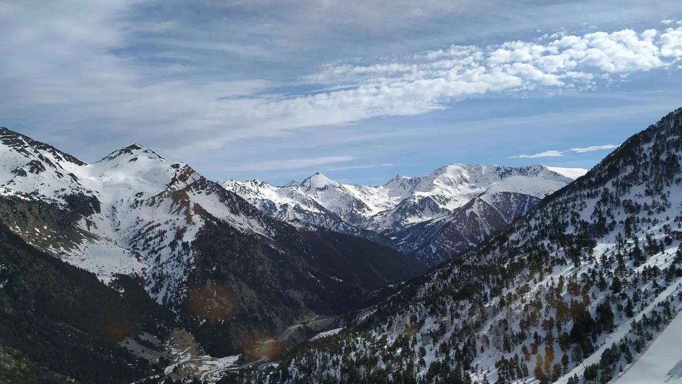 Breathtaking view of snowcapped mountains in Ordino, Andorra under a bright blue sky.