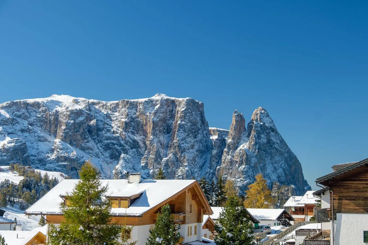 Scenic winter view of chalets and snow-covered mountains in Trentino-South Tyrol, Italy.