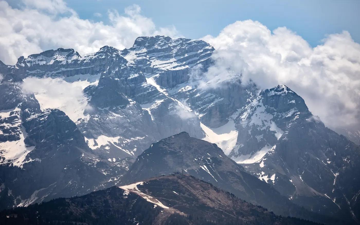 Breathtaking view of snow-covered mountains under a blue sky in Madonna di Campiglio, Italy.