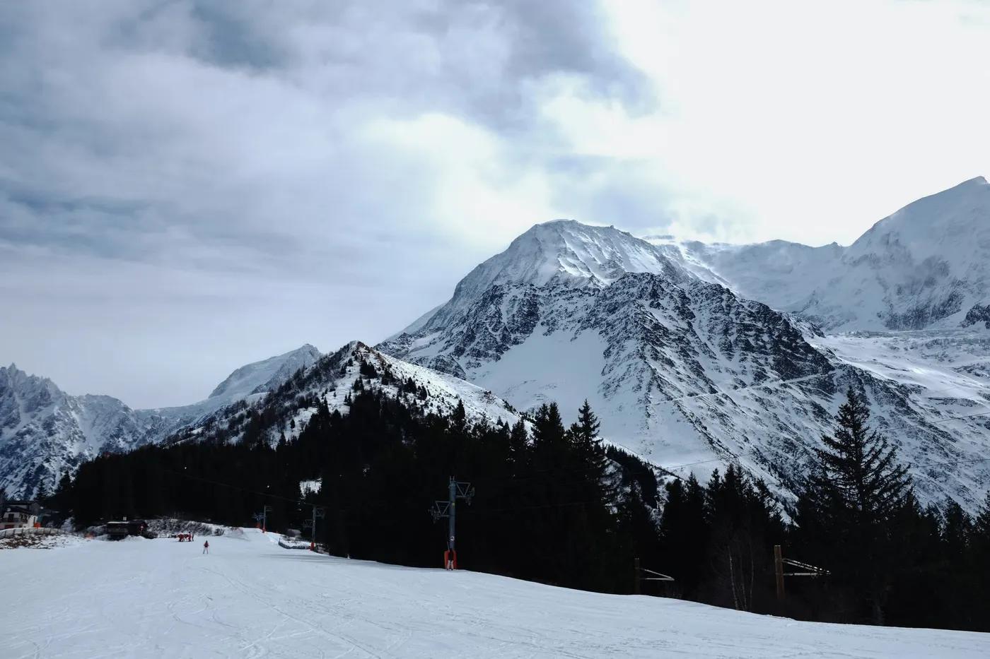 A breathtaking view of snow-covered mountains with conifer forests, ideal for winter travel.