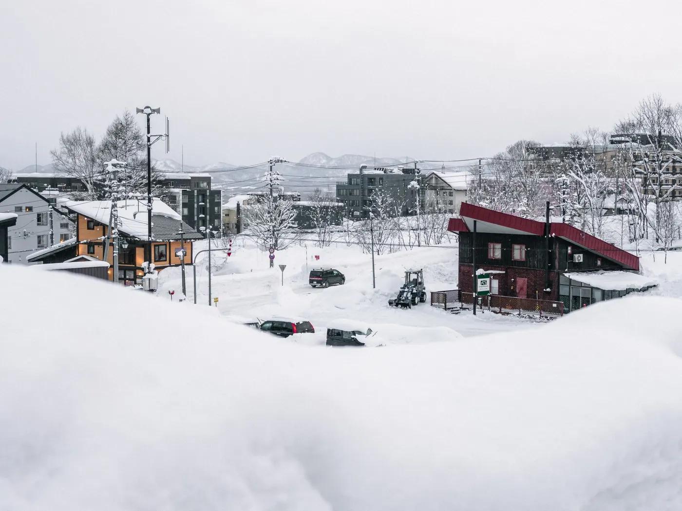 A serene winter scene in snowy Niseko, Hokkaido, showcasing a tranquil village covered in snow.