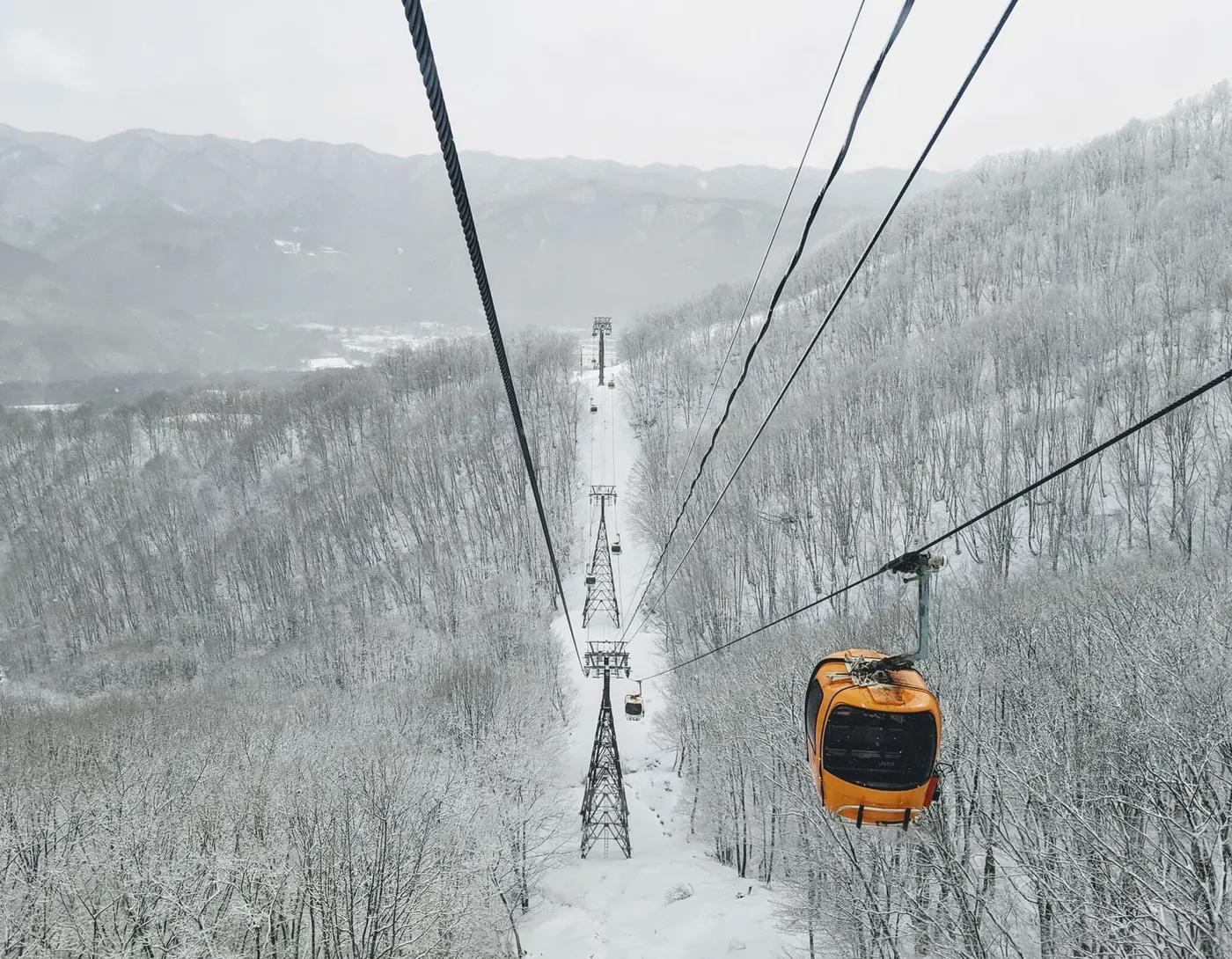 Cable car journey over snow-covered forests in Hakuba, Nagano, Japan, during winter.