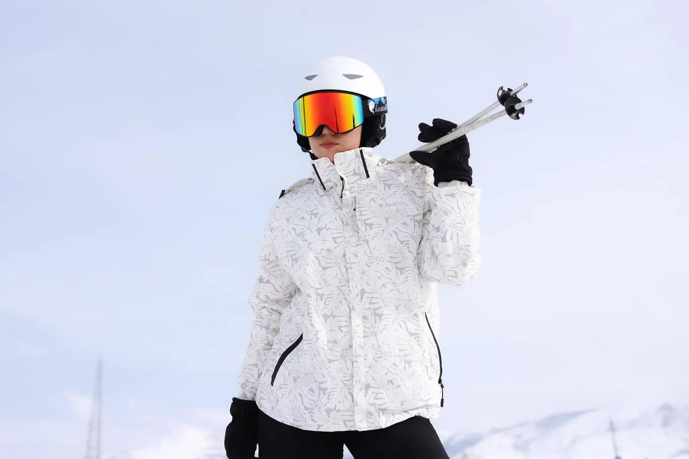 Adult skier in white gear on a bright snow-covered mountain holding ski poles, ready for adventure.