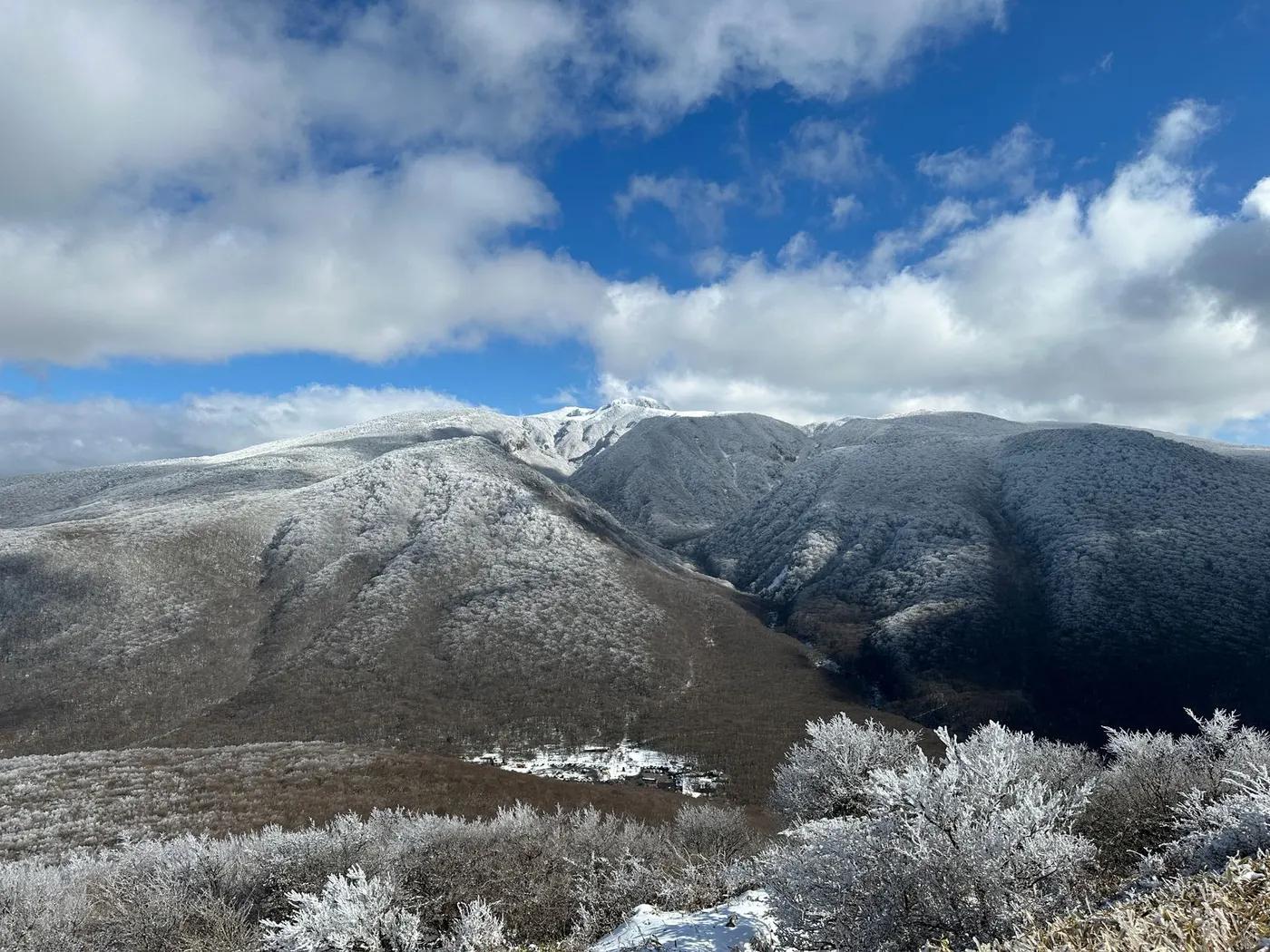 A breathtaking view of snow-covered hills under a bright winter sky in Jeju, South Korea.