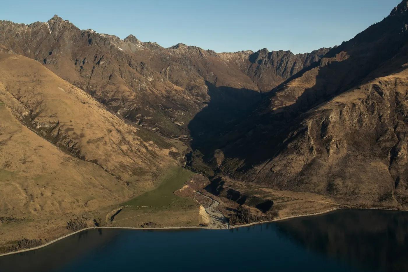 Stunning aerial view of the rugged mountains and serene water in Queenstown, New Zealand.