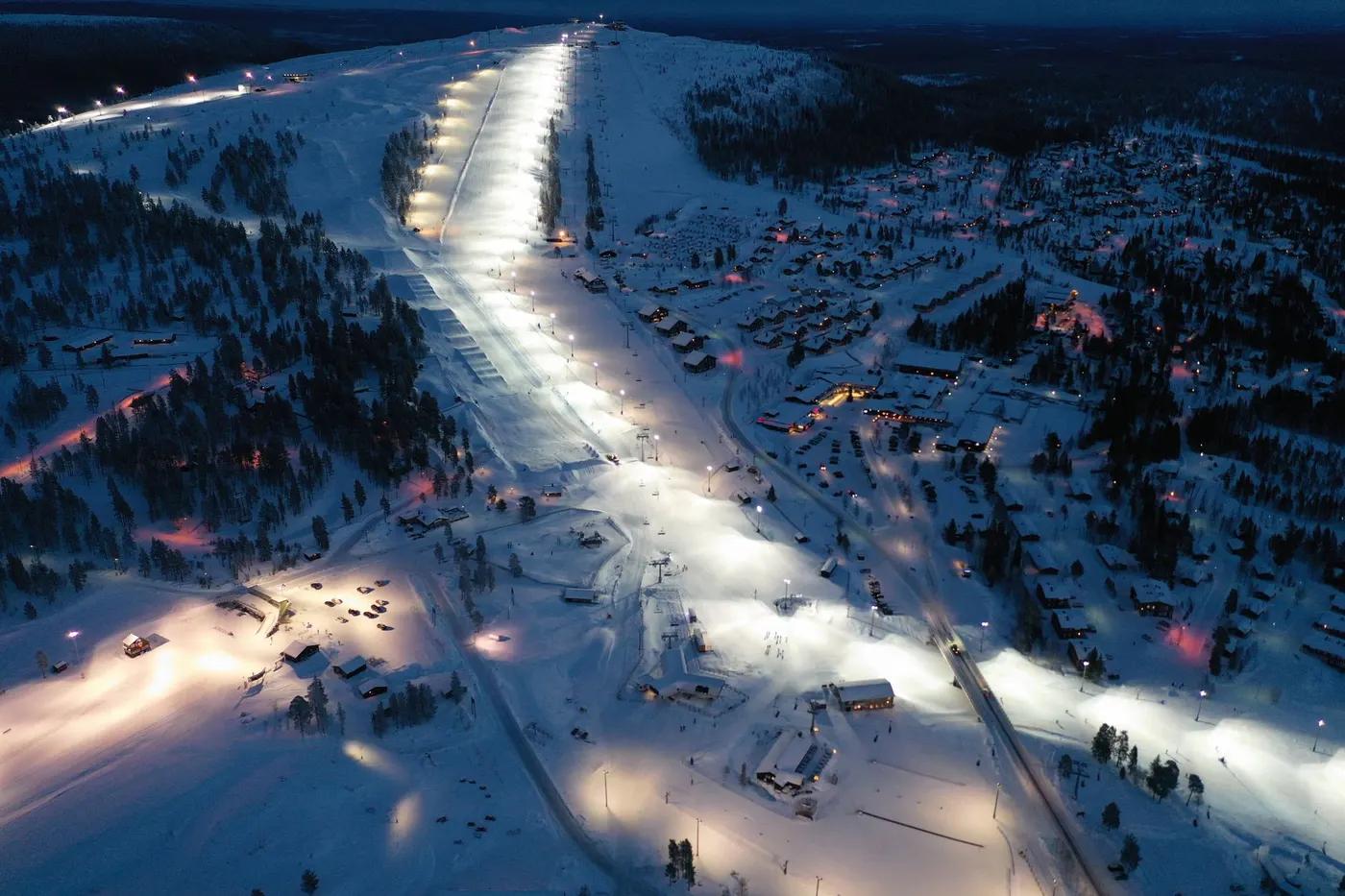 Illuminated ski slopes at night in a snowy landscape near Älvdalen, Sweden.