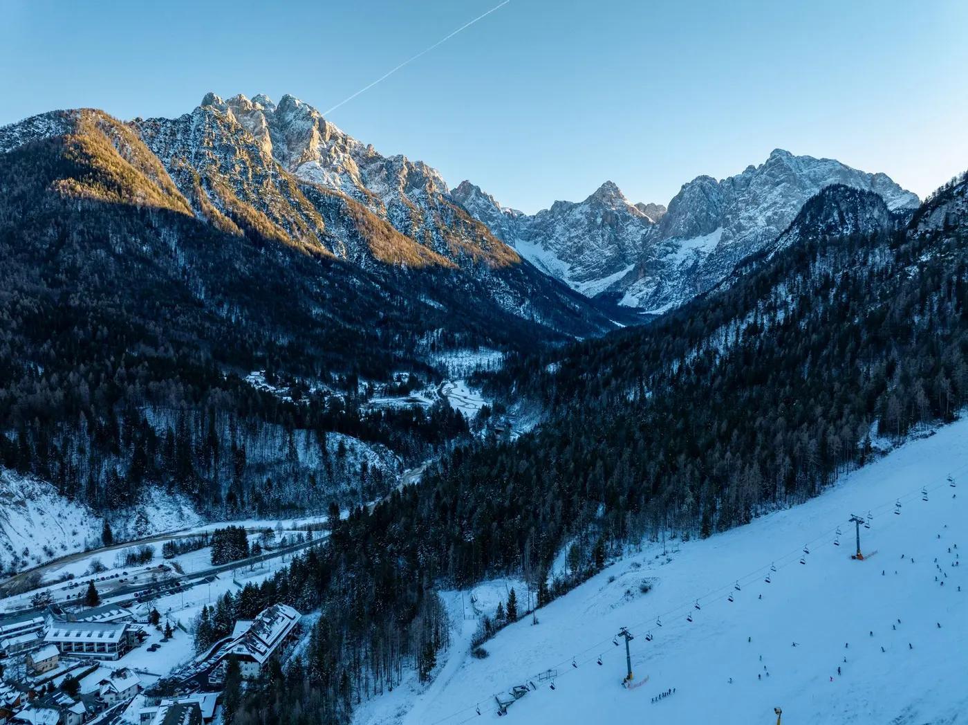 Breathtaking winter view of snow-covered mountains in Kranjska Gora, Slovenia, with clear blue skies.