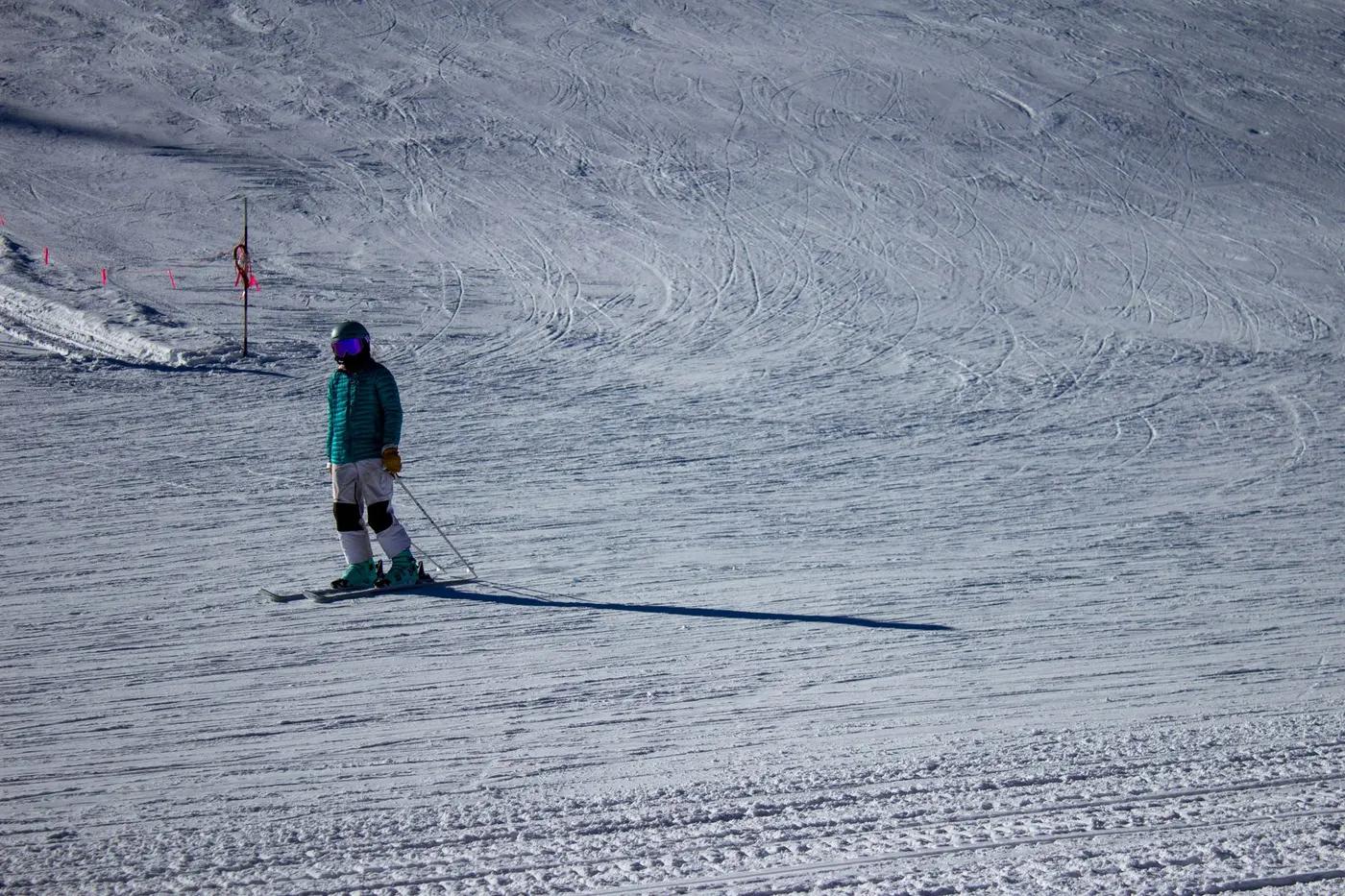 A skier in vibrant winter clothing glides down the snowy slopes at Winter Park, Colorado.