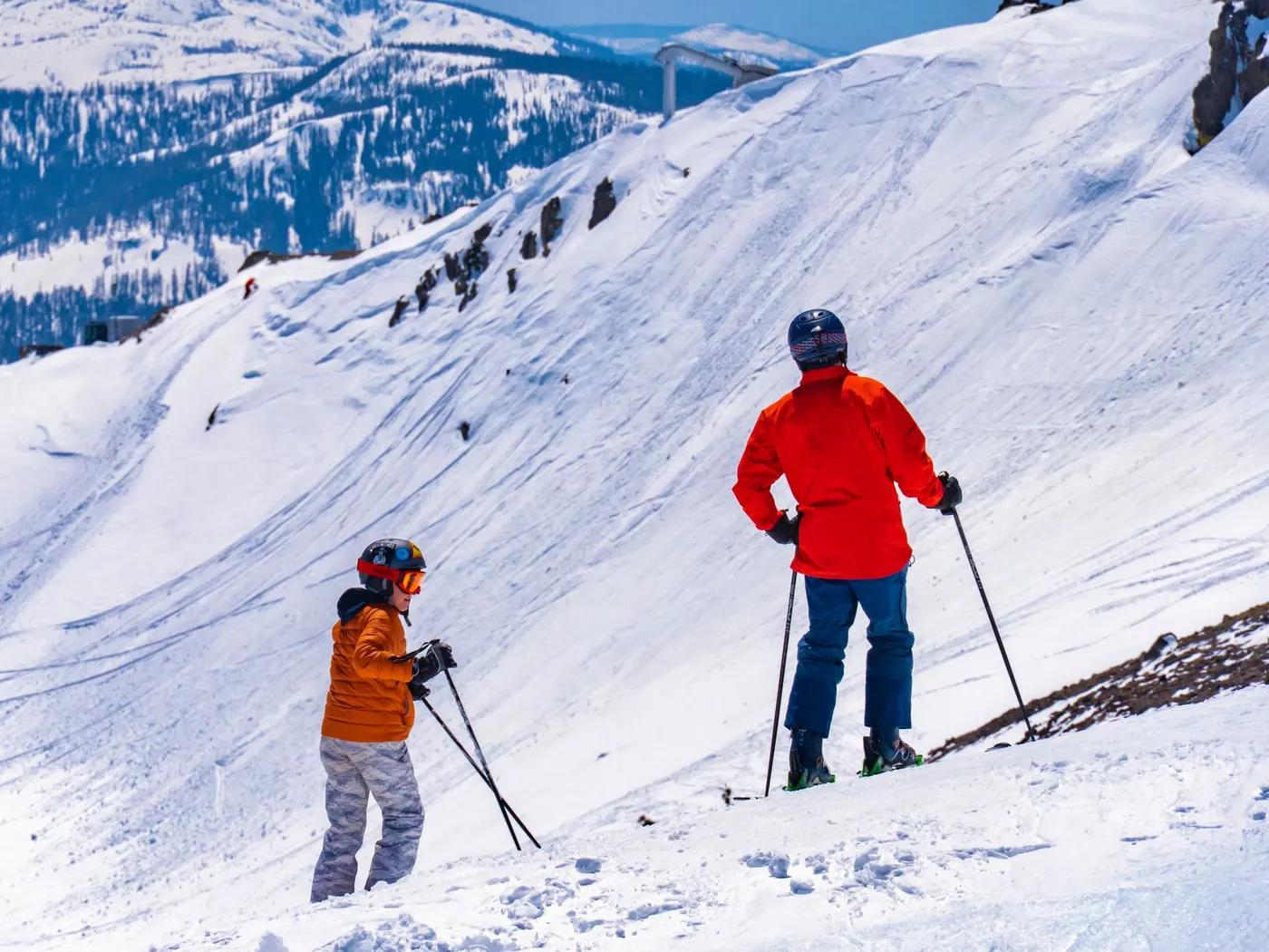 Two skiers navigating a snowy mountain slope in the United States during winter.