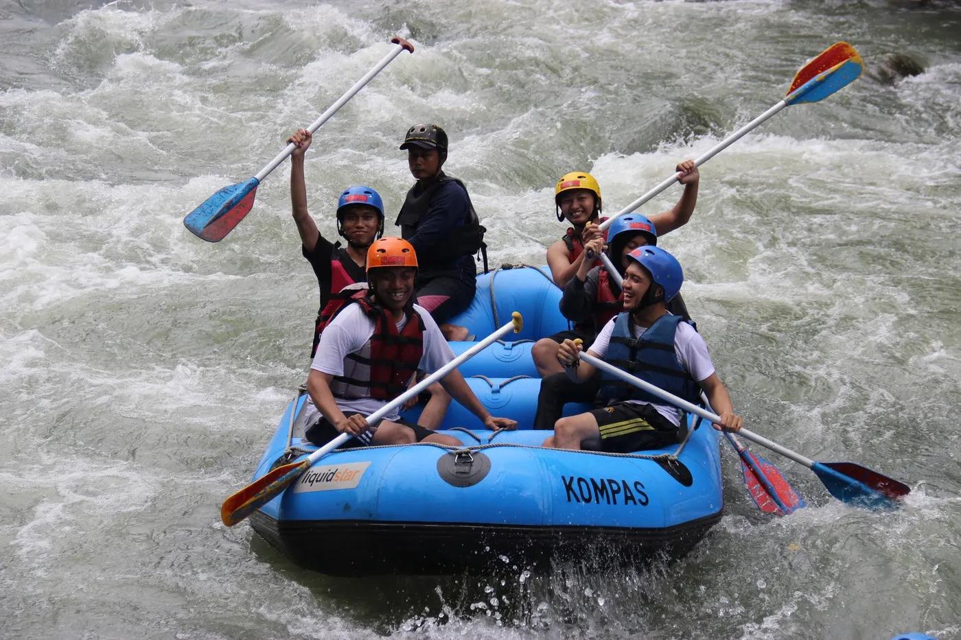Group enjoying thrilling white water rafting on a river in Yogyakarta, Indonesia.