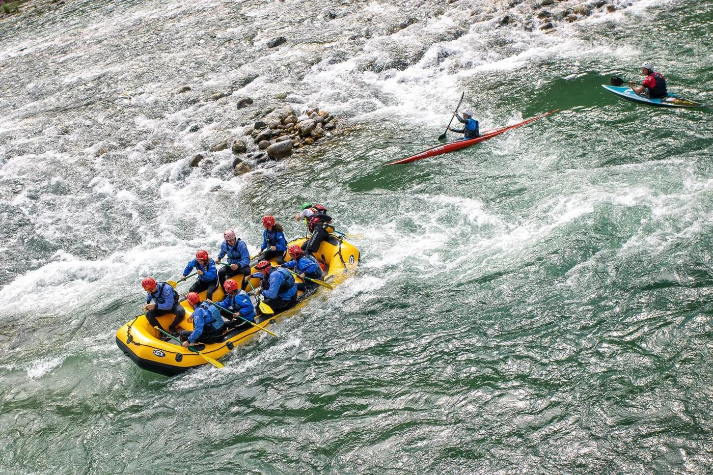 Group enjoying whitewater rafting on a lively river in Valstagna, Italy.
