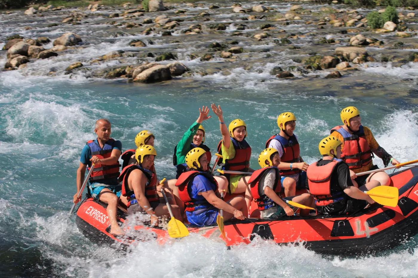 A group of adults enjoys an exciting whitewater rafting trip on a scenic river.
