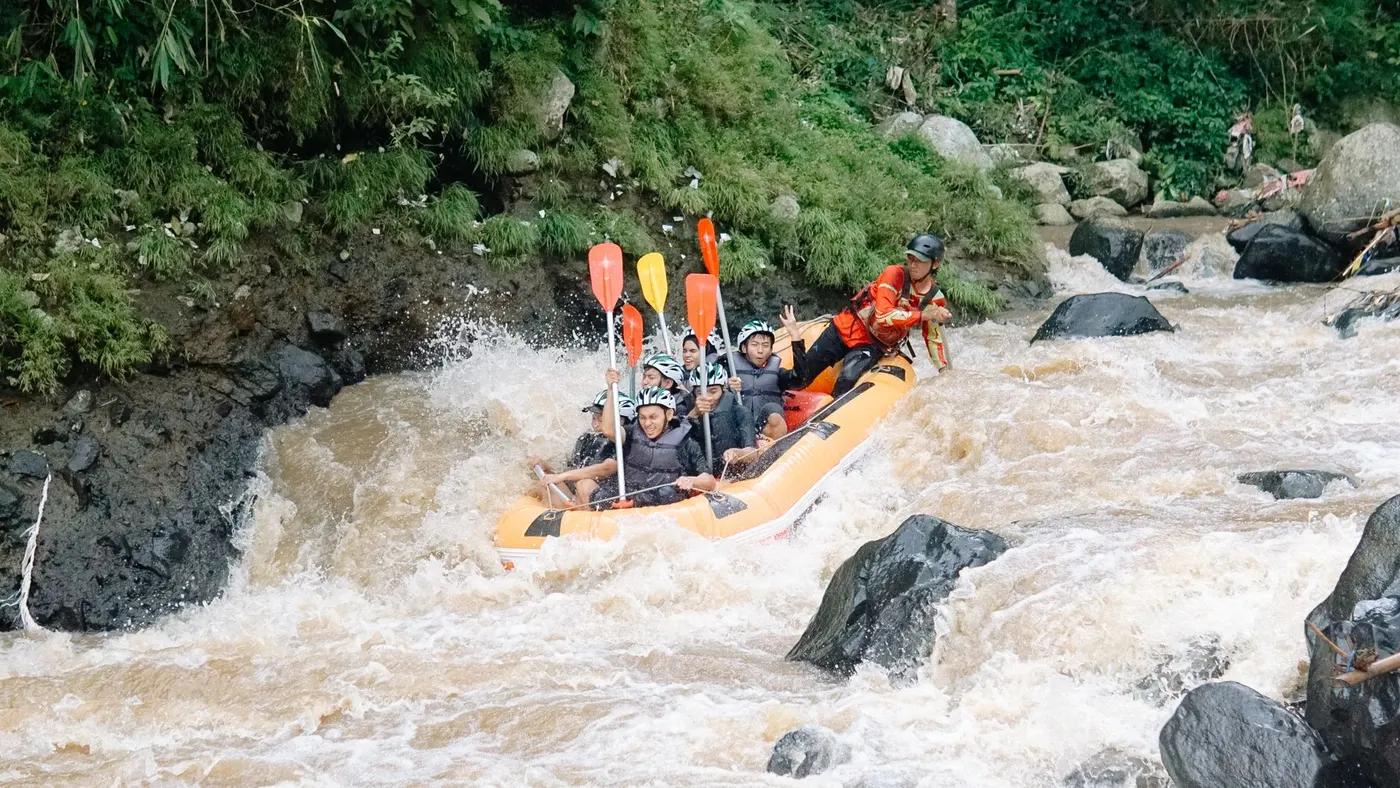 Group of adults white water rafting on a turbulent river, showcasing adventure and excitement.