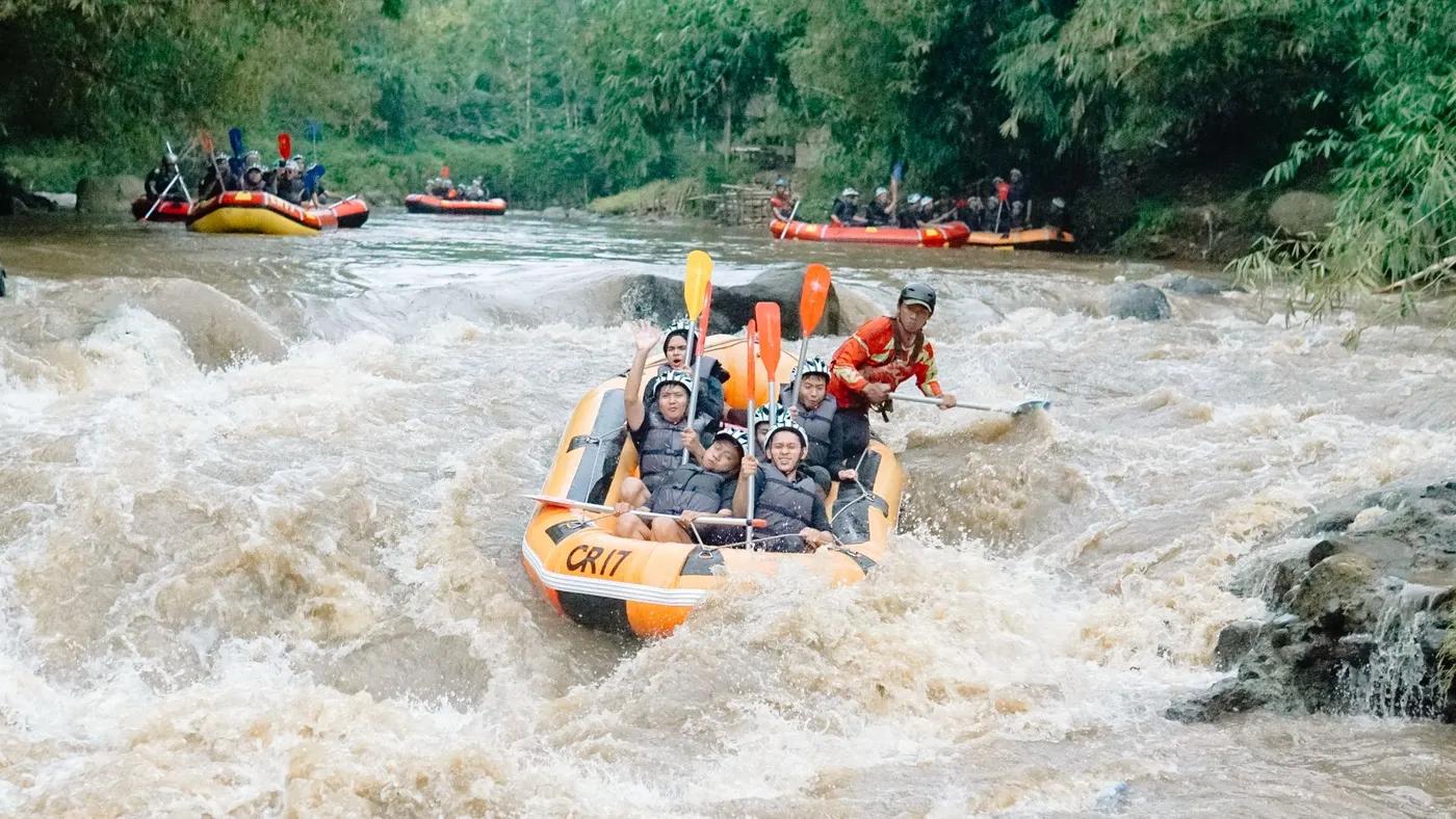 Exciting whitewater rafting with group navigating turbulent river in an inflatable raft amid lush greenery.